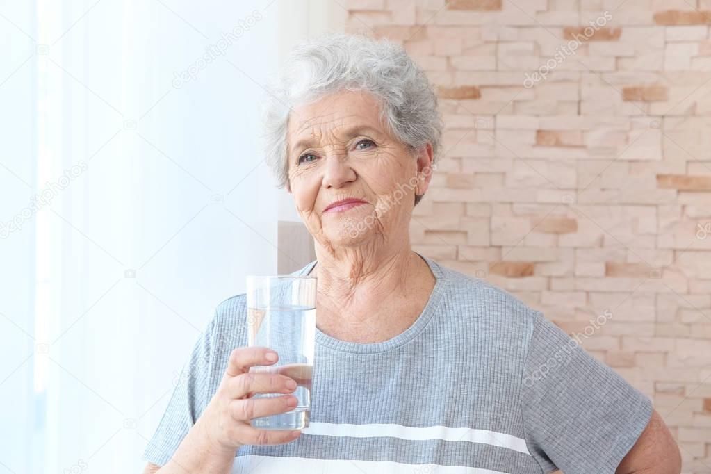Elderly woman holding glass of water