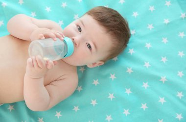 Şişeyle evde yatakta yatarken şirin bebek