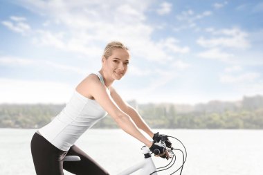 Genç kadın bisikletçi binicilik bisiklet Nehri yakınında