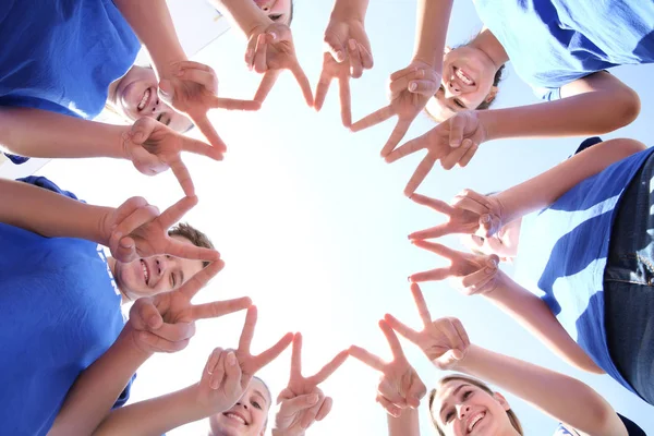 Équipe de bénévoles mettant leurs mains ensemble comme symbole d'unité, vue du bas — Photo