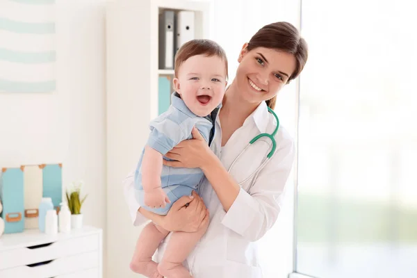 Kvinnliga läkare och söt liten baby i klinik. Baby hälsokoncept — Stockfoto