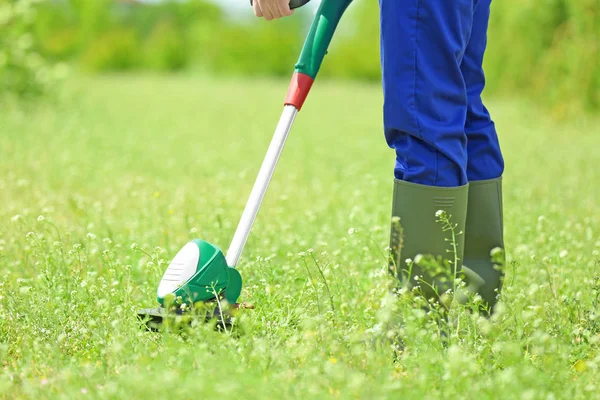 Worker mowing lawn with grass trimmer — Stock Photo, Image
