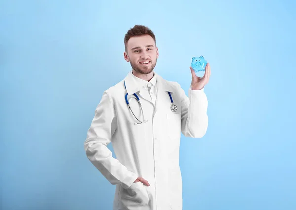 Young doctor holding piggy bank — Stock Photo, Image