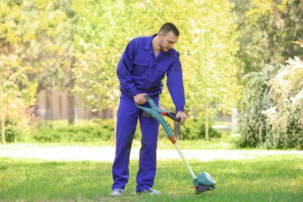 Werknemer maaien gazon met gras trimmer — Stockfoto