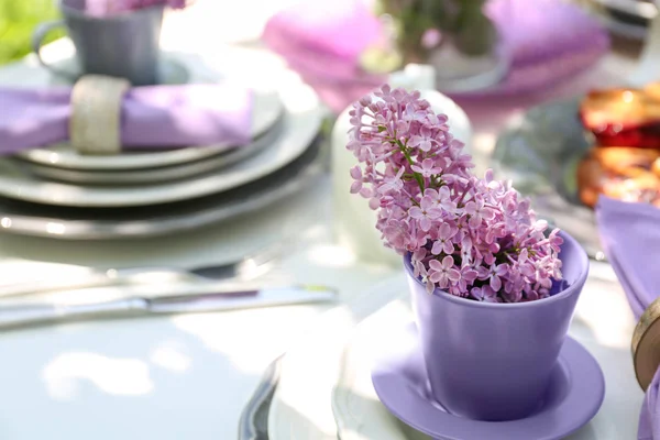 Tea cup with lilac flowers — Stock Photo, Image