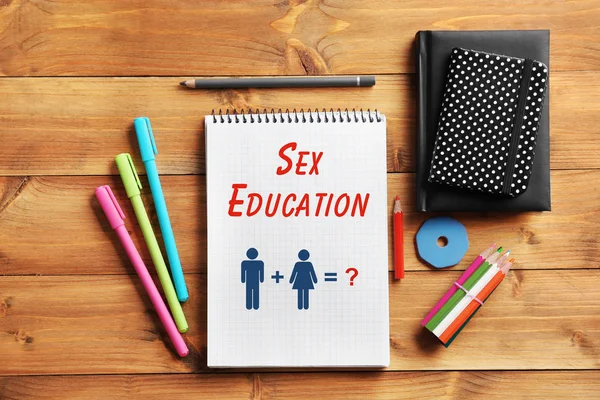 Concepto de educación sexual. Cuaderno y papelería sobre fondo de madera —  Fotos de Stock