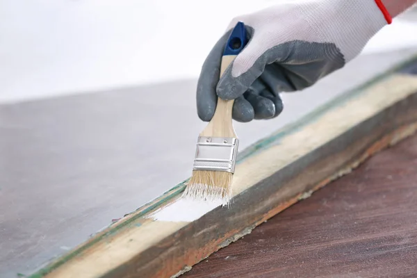 Worker painting frame of old window lying — Stock Photo, Image