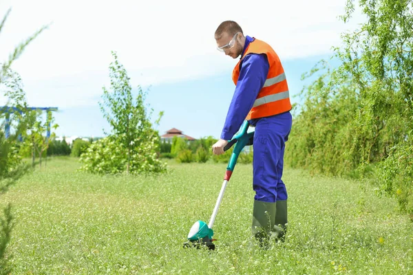 Werknemer maaien gazon met gras trimmer — Stockfoto