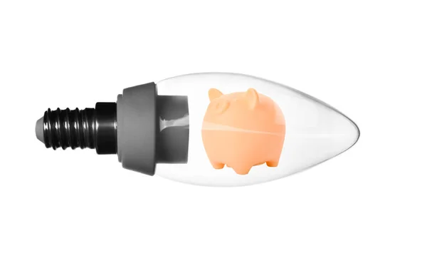 Piggy bank uvnitř žárovky na bílém pozadí. Zvýšení nákladů na elektrickou energii — Stock fotografie