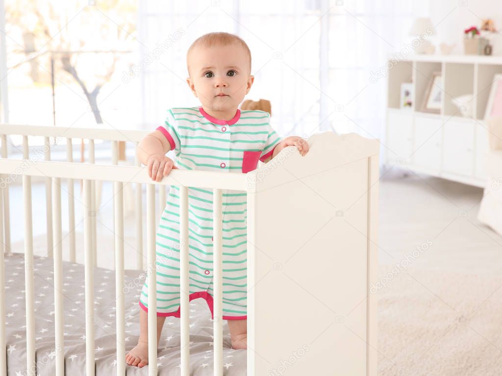 little baby standing in crib 