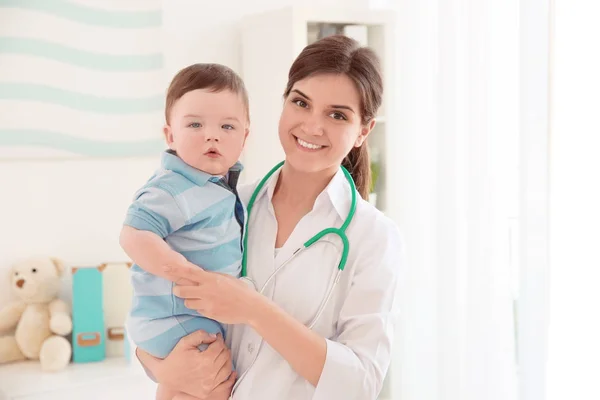 Kvinnliga läkare och söt liten baby i klinik. Baby hälsokoncept — Stockfoto