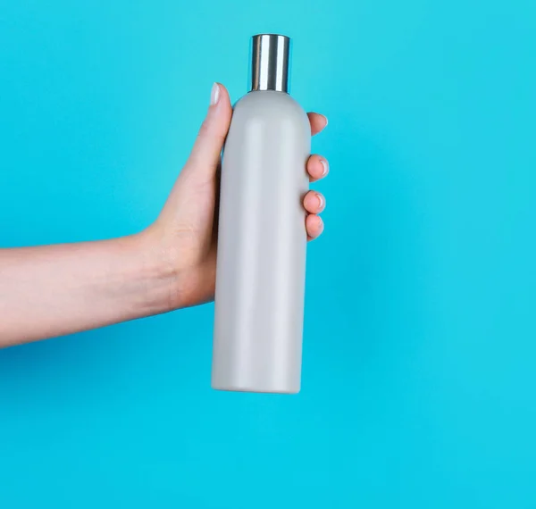 Hand med flaska kosmetisk produkt — Stockfoto