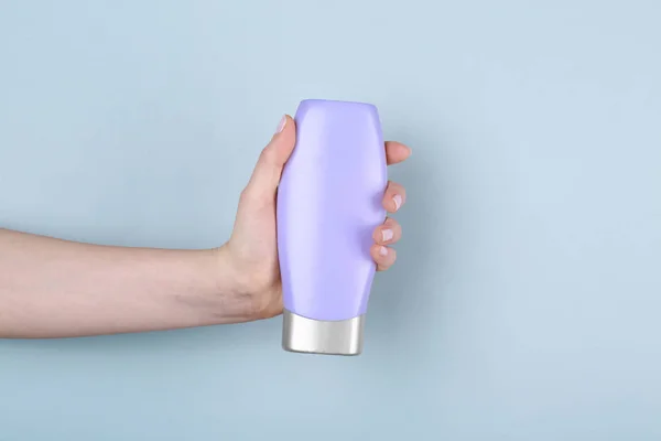 Ręka z butelki produktu kosmetycznego — Zdjęcie stockowe