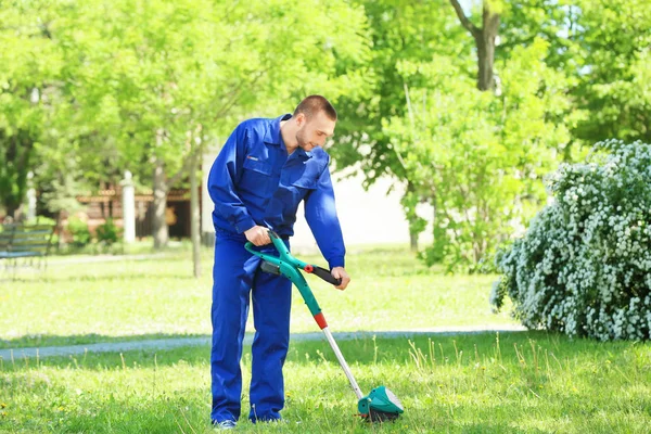 Pracownik, koszenie trawników z podkaszarka do trawy — Zdjęcie stockowe