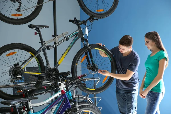 Mann zeigt Frau im Geschäft Fahrrad — Stockfoto