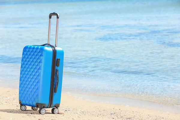 Упакованный чемодан на берегу моря — стоковое фото