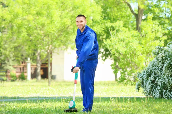 Werknemer maaien gazon met gras trimmer — Stockfoto