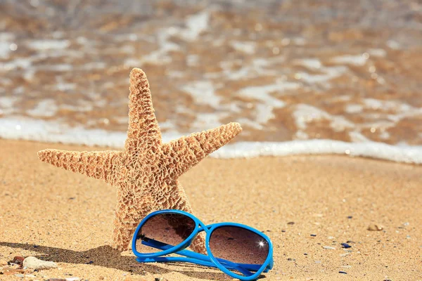 Sunglasses and starfish on sand — Stock Photo, Image