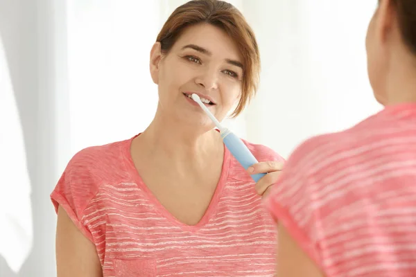 Mujer mayor limpiando dientes — Foto de Stock