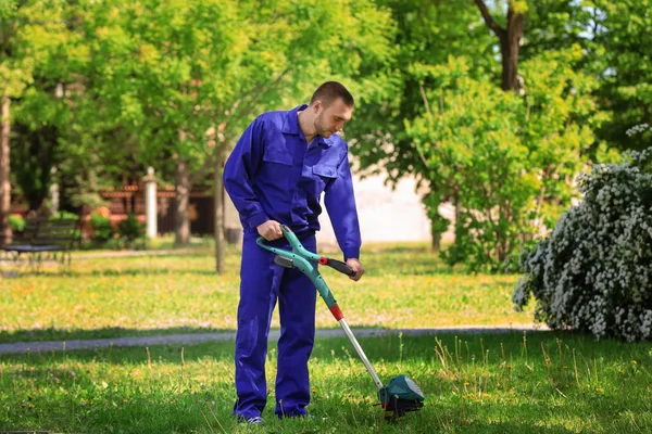 Pracownik, koszenie trawników z podkaszarka do trawy — Zdjęcie stockowe