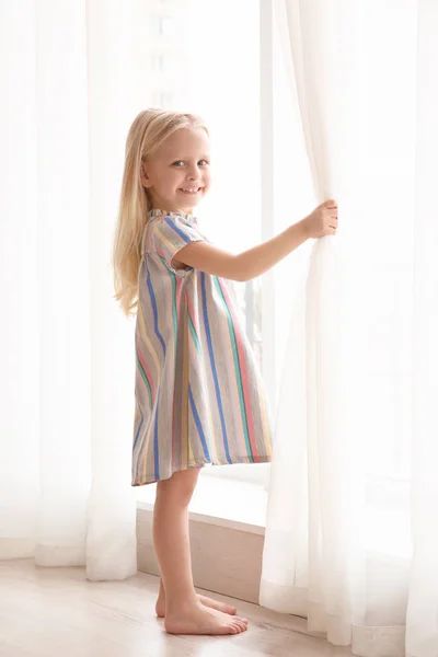 Girl opening curtains — Stock Photo, Image
