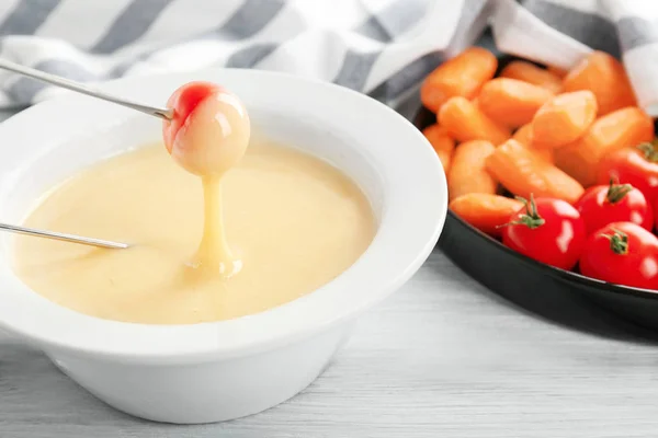 Tomate mergulhado em fondue de queijo — Fotografia de Stock