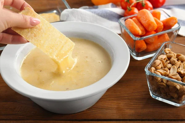 Aardappelchips dompelen in kaasfondue — Stockfoto