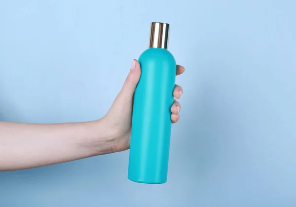 Hand met fles cosmetisch product — Stockfoto