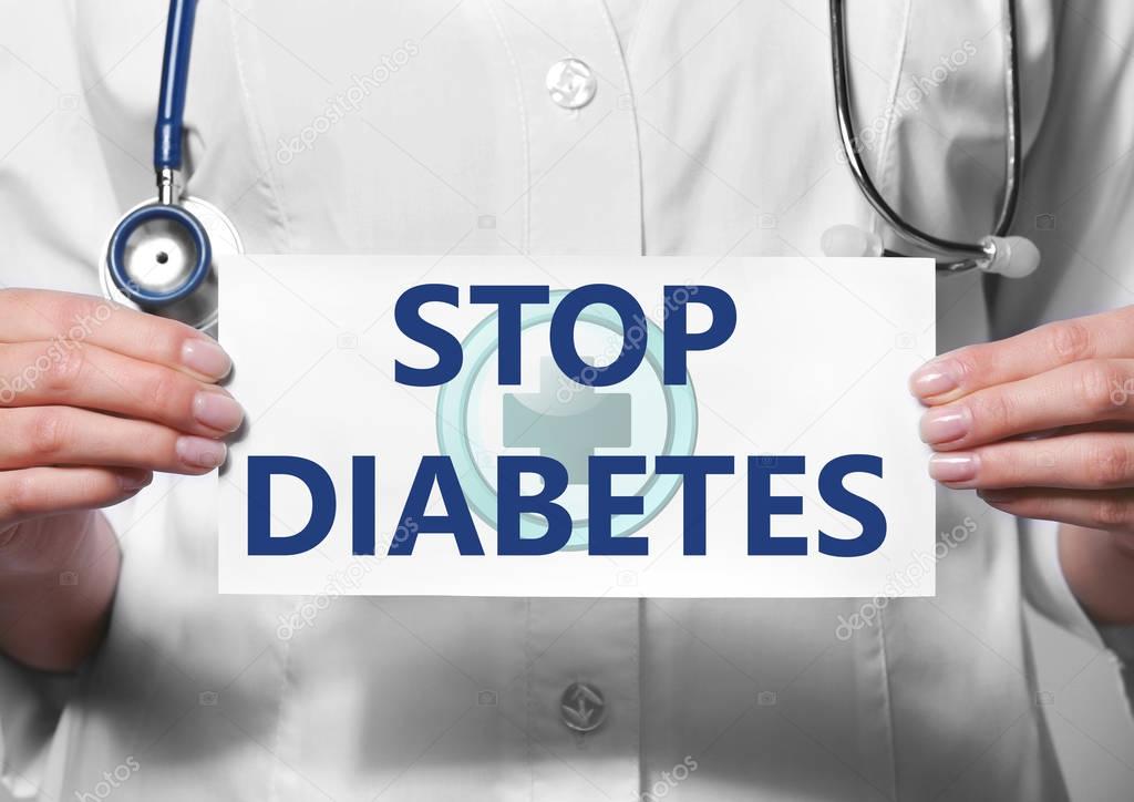 Health care concept. Doctor holding paper with text STOP DIABETES, closeup