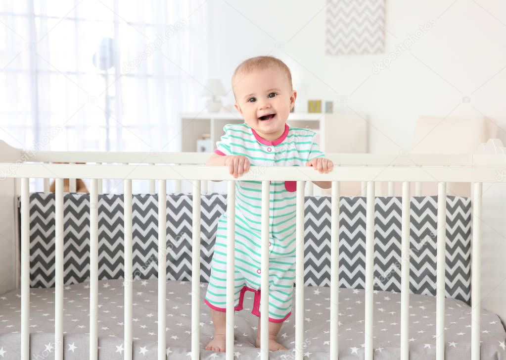 little baby standing in crib 