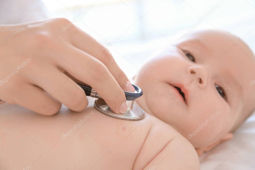 Doctor examining little baby