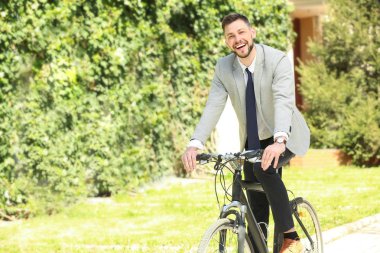 Yakışıklı genç işadamı binicilik bisiklet güneşli günü açık havada
