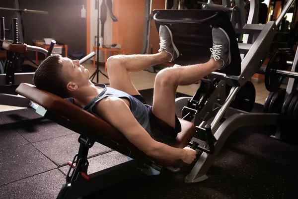 Nogi trening sportowy młodego człowieka w siłowni — Zdjęcie stockowe