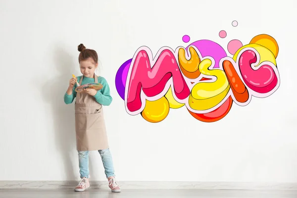 Concepto de infancia. Pintor pequeño y palabra colorida MÚSICA sobre fondo de pared blanco —  Fotos de Stock