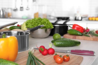 Taze sebze ve ahşap masa üzerinde sınıflar yemek pişirmek için mutfak eşyaları