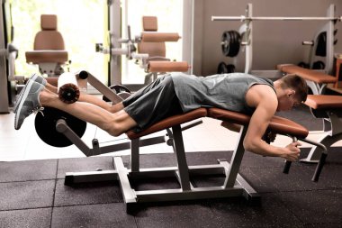Sportif genç adam eğitim bacaklar içinde jimnastik salonu