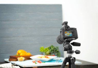 Gıda çekerken tripod üzerinde profesyonel fotoğraf makinesi