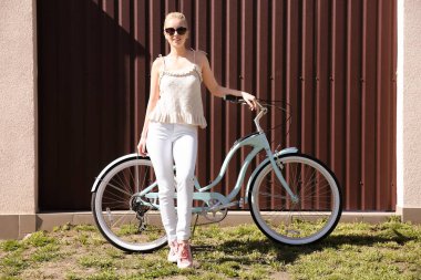 Renk duvarının yakınında bisiklet ile genç gülümseyen kadın