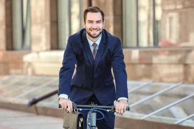 Yakışıklı genç işadamı binicilik bisiklet açık havada