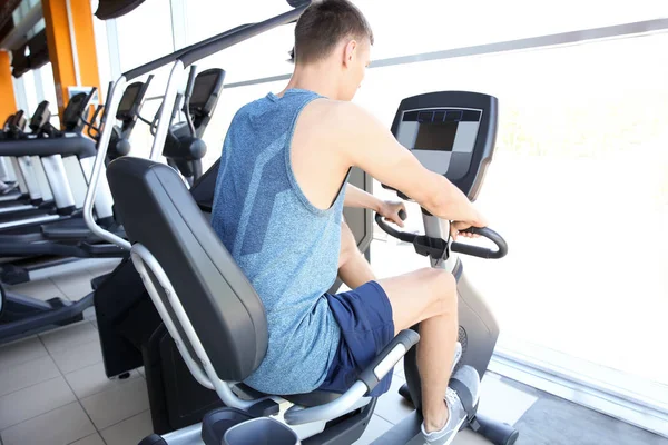 Sporty young man training legs in gym — Stock Photo, Image