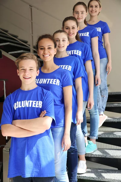 Grupo de jóvenes voluntarios en la escalera interior — Foto de Stock