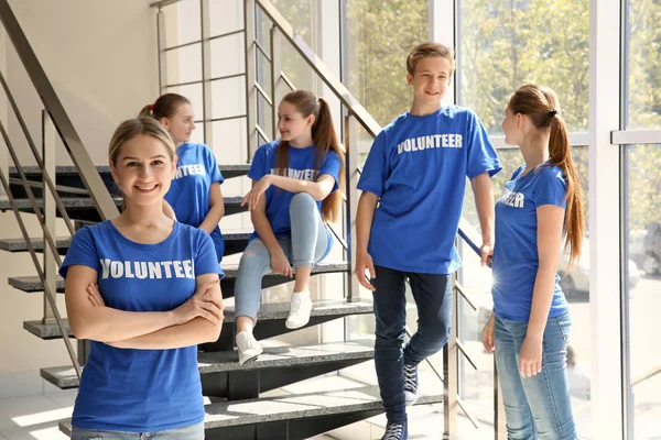 Grupo de jovens voluntários em escadaria perto da janela — Fotografia de Stock