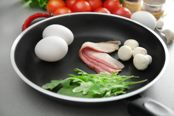 Az ízletes reggeli tojás serpenyőben a táblázat alapanyagokat — Stock Fotó