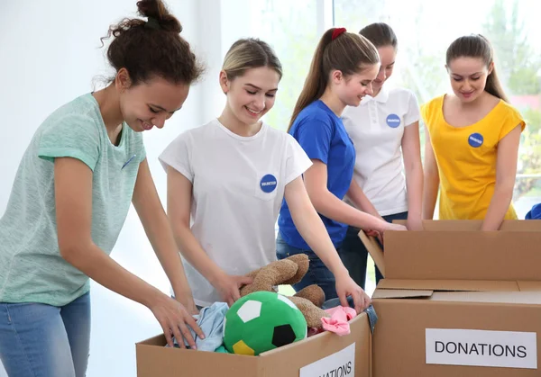 Giovani volontari con scatole di donazioni al chiuso — Foto Stock