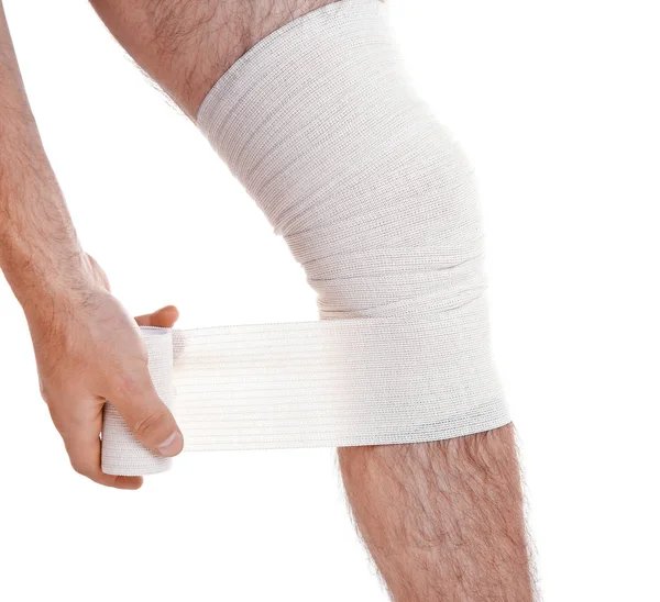 Man tillämpar bandage på benet — Stockfoto