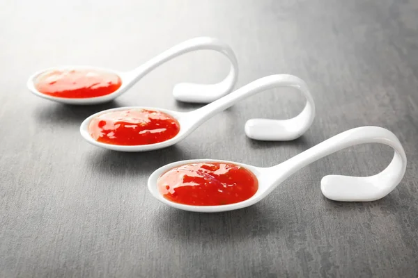 Molho de pimentão saboroso em colheres na mesa — Fotografia de Stock