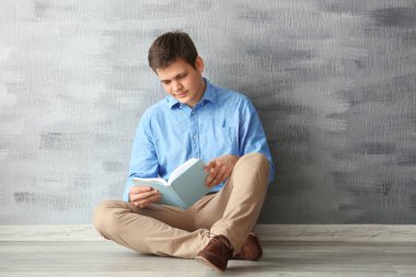 Genç adam kitap okuyor. 