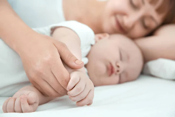근접 촬영, 집에서 침대에 누워 귀여운 잠자는 아기와 젊은 여자 — 스톡 사진