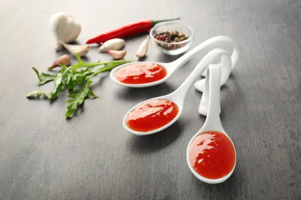 Salsa di peperoncino saporita in cucchiai su tavolo — Foto Stock