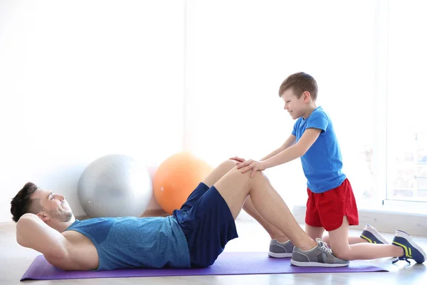Μπαμπάς Κάνει Sit Ups Γιο Στο Γυμναστήριο — Φωτογραφία Αρχείου